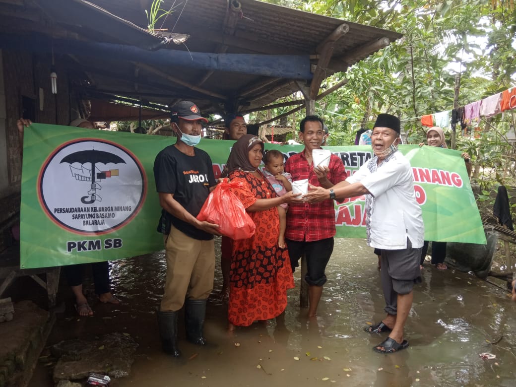 BAGIKAN NASI BUNGKUS: Persaudaraan Keluarga Minang Sapayung Basamo Balaraja, saat memberikan nasi bungkus kepada warga korban Banjir Desa Pasir Ampo, Kecamatan Kresek, Kabupaten Tangerang, Minggu (7/2/2021).